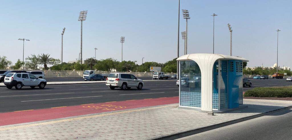 a bus stops in front of a public restroom.