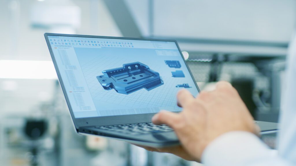 a man is using a laptop in a factory.
