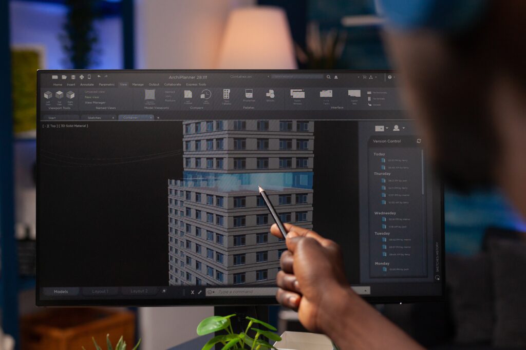 a person is using a computer to draw a building.