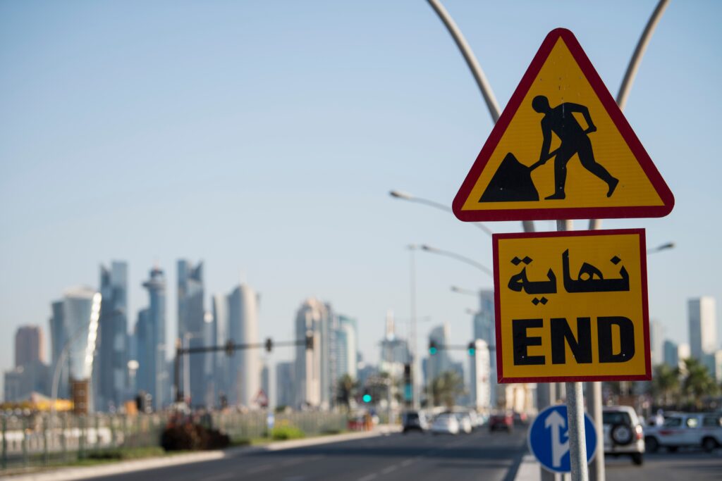 a road sign with an end sign in front of a city.