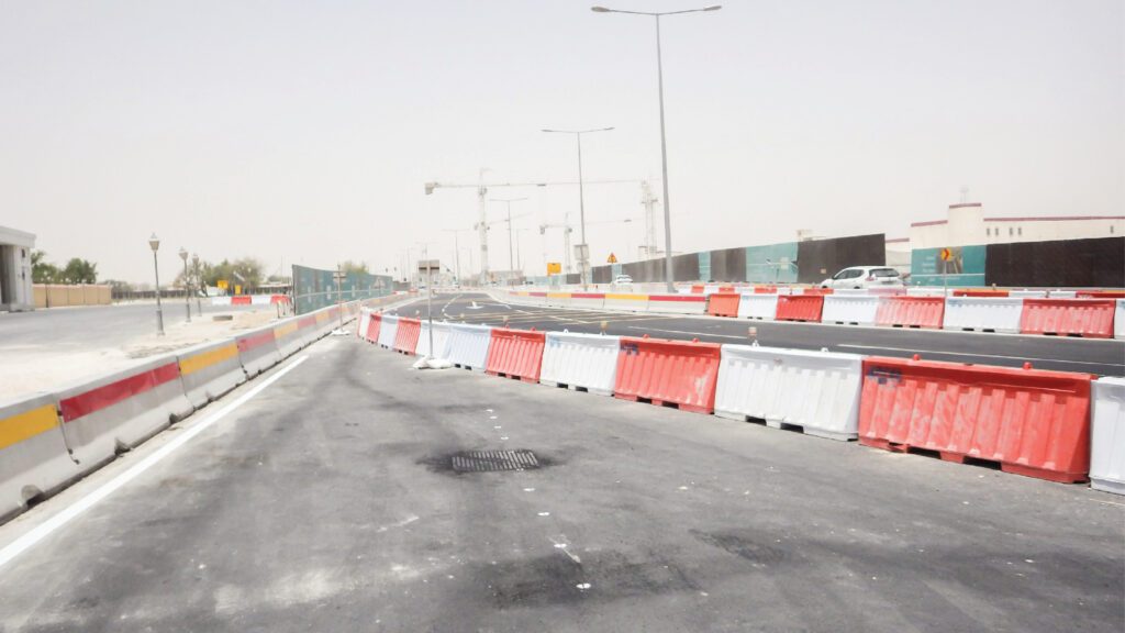 a road with red and white barriers in front of it.
