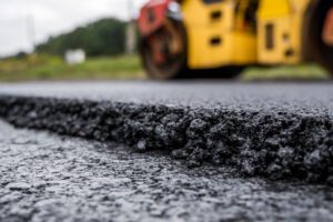 a truck is driving down a road with a paved road.